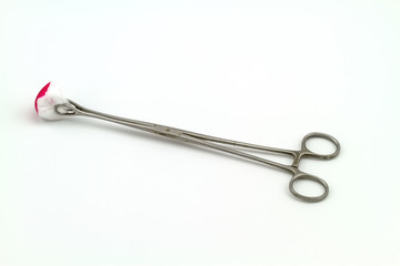 Surgical instrument (straight hemostat, sponge forceps) cotton wool and bloodstain on white background