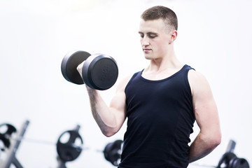 Obraz na płótnie Canvas Athletic man with a dumbells in gym