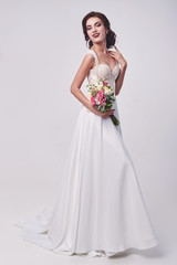 Fototapeta na wymiar Woman in wedding dress with flowers' bouquet.