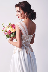 Woman in wedding dress with flowers' bouquet.