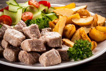 Grilled meat with baked potatoes and vegetables 