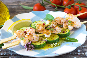 Shrimps skewers with zucchini on wooden background