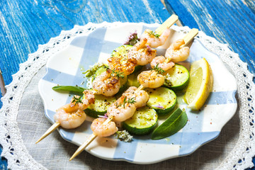 Shrimps skewers with zucchini on wooden background