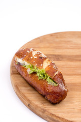 Sandwich roll with ham tomato and lettuce.