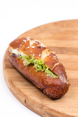 Sandwich roll with ham tomato and lettuce.