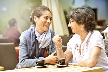 Senior woman with home carer having coffee together