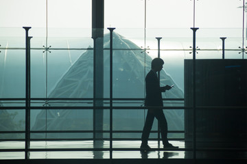 Fototapeta premium Silhouette of business man hold telephone into an Airport