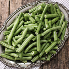 Bunch of freshly picked green beans on a wooden surface.