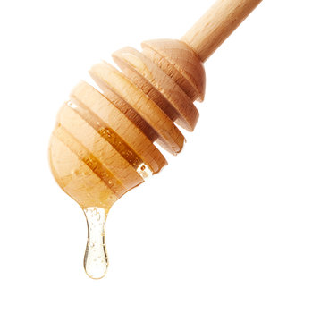 Honey dripping from wooden stick