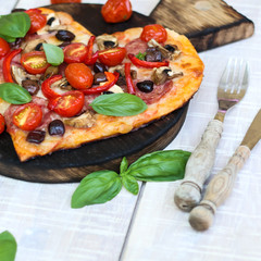 Pizza with pepperoni, tomatoes, mozzarella, on vintage wooden table background. Valentines Day concept