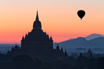 Silhouette of temple and hot air balloon at dawn, Myanmar