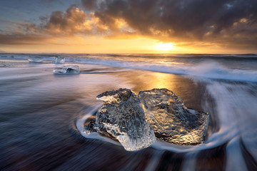 Long exposure, iceberg on black sand beach at sunset, iceland