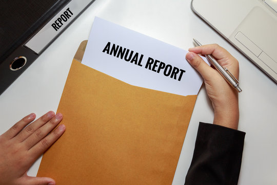 Businesswoman Opening Annual Report Document In Letter Envelope