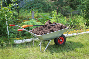 Cart with ground and the shovel in tha garden
