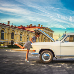 Young woman repairing the retro car