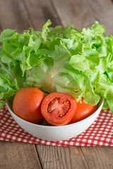 Fresh vegetable salad with green oak and tomato being prepared b