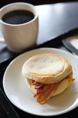Bacon and fried egg roll with coffee