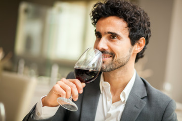 Man toasting wineglasses in a luxury restaurant