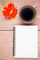Gerbera flower,coffee, notebook on the wood table