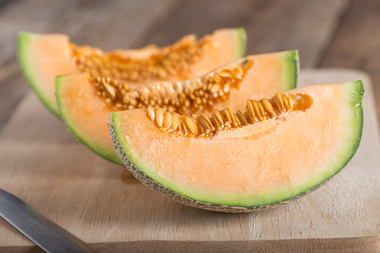 Fresh melon sliced on wooden board.