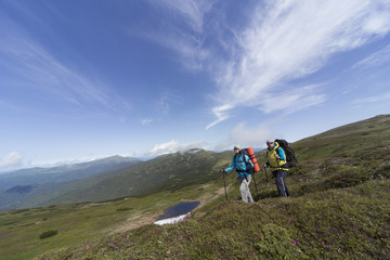 Fototapeta premium Summer hiking in the mountains with a backpack .
