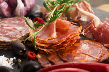a pile of different spanish embutido, jamon, chorizo and lomo em