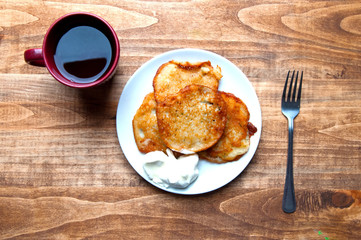 Potato pancakes and tea on a wooden table. Background
