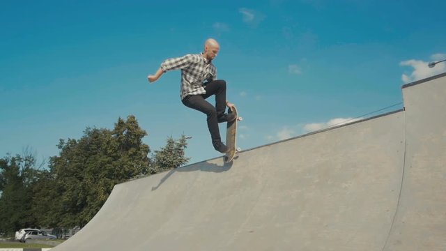 skateboarder in action on a ramp, doing stall trick, rock to fakie on skateboard