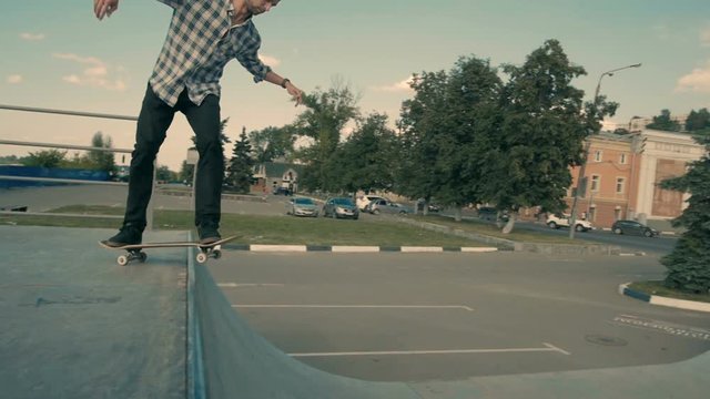 Skateboarder is dropping with his Skateboard a Ramp, rock to fakie