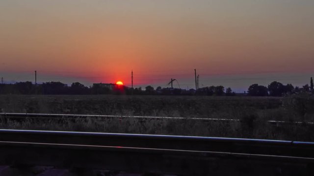 Timelaps sunset over a field along the railway