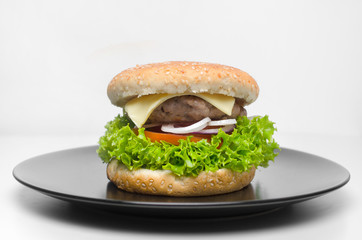 Burger on a black plate on a white background