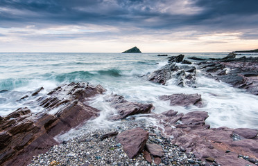 stormy and dramatic clouds over rocky beach