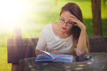 Girl with book reading at the park