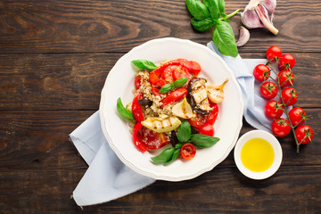 Quinoa salad with grilled vegetables, rustic wooden table, top view