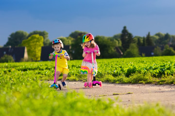 Kids riding scooter on sunny summer day