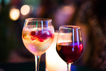 Fruity champagne cocktail/ Candlelit colourful drinks. Prosecco cocktail with seasonal fruits and red wine.