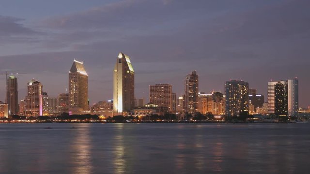 Time Lapse of downtown San Diego as the sun sets with reflections of the buildings in the water.