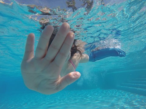 Ni&ntilde;a buceando con el brazo escayolado.