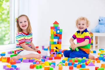 Fototapeta premium Kids playing with colorful toy blocks