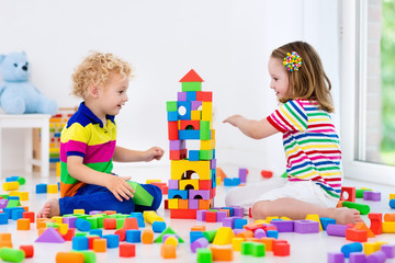 Kids playing with colorful toy blocks