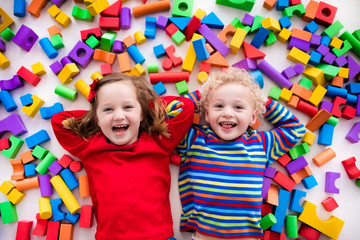 Children playing with colorful blocks. - obrazy, fototapety, plakaty