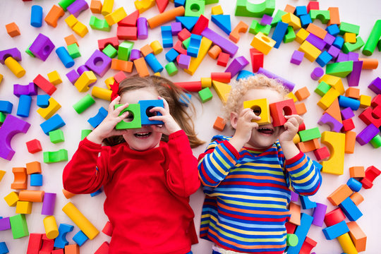 Naklejki Children playing with colorful blocks.