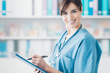 Smiling doctor writing medical reports