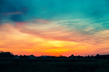 Rural landscape in evening at sunset with cloudy sky