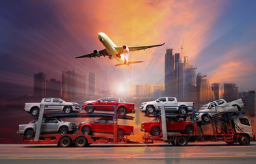 The trailer transports  new cars on highway with big city background use for transportation...