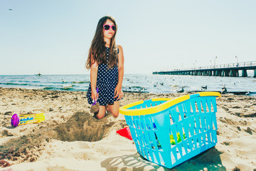 Lovely gorgeous little girl playing with sand.