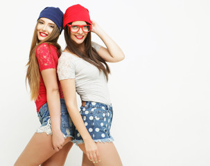 Two young girl friends standing together and having fun. 