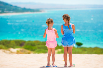 Adorable little girls having fun during beach vacation