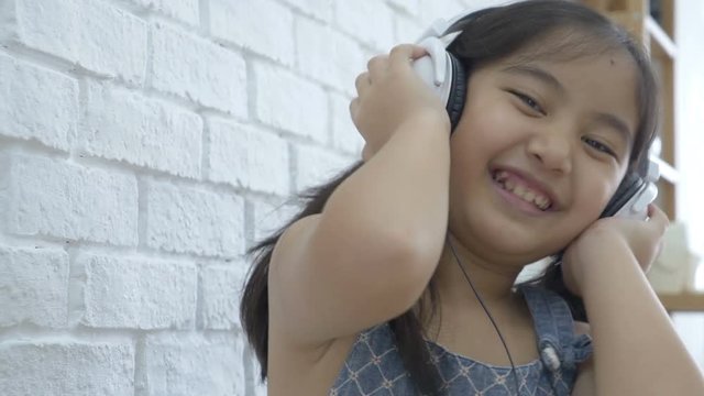 4K : Attractive Asian girl listening music by headphone in the room