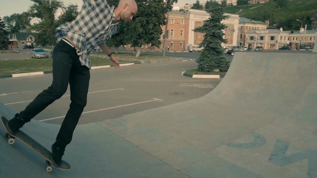 A skateboarder defies gravity as he rides his skateboard in an empty ramp